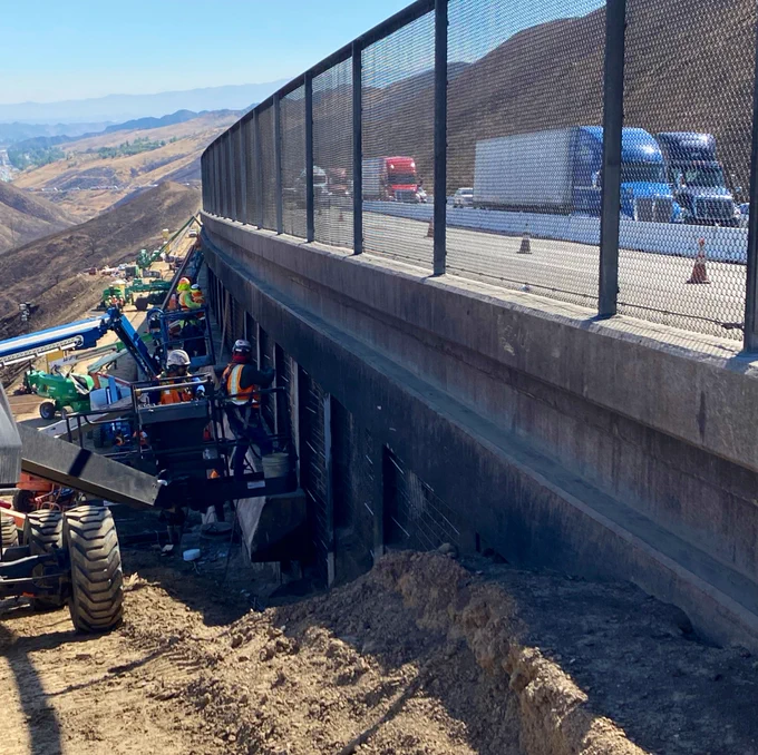 A picture of Northbound I-5 as trucks travel near work crews.