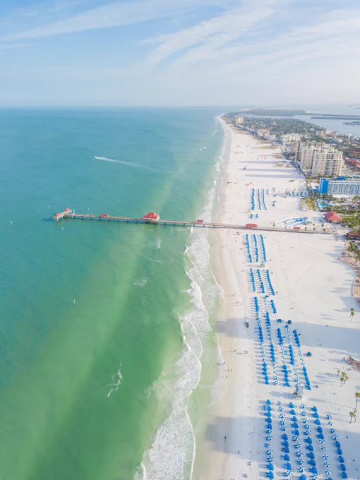 An aerial view of Clearwater Beach and the emerald green waters of the Gulf of Mexico on a sunny morning.