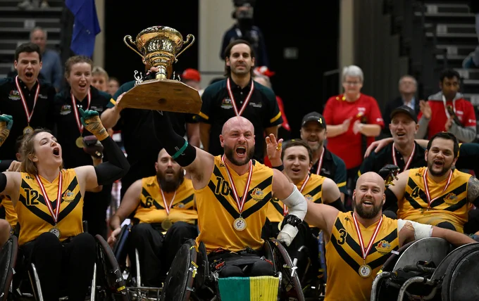 Australian team holding the trophy and celebrating together. 