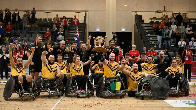 Australian team holding the trophy and celebrating together. 