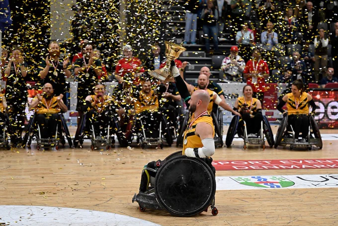 Australian rugby player Chris Bond holding the trophy in front of his teammates.  