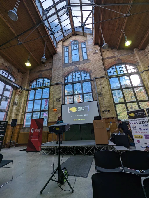 A photo of Amy Newton in front of a projector screen in a former boiler room
