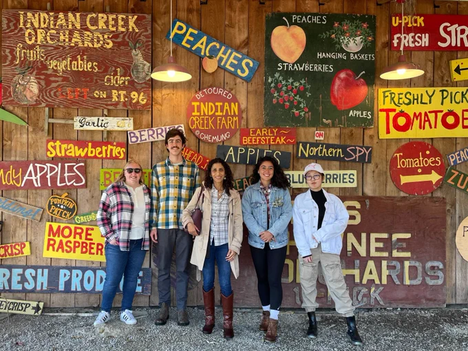 NAP lab members smiling in front of a wall featuring orchard themed signs.