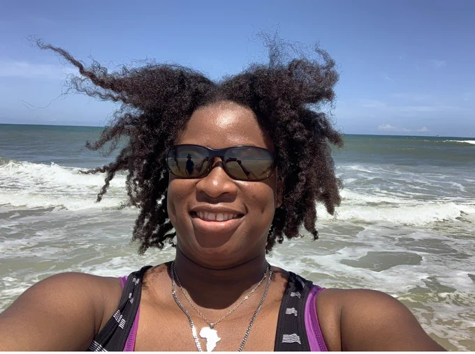 Black female selfie headshot in front of a beach!