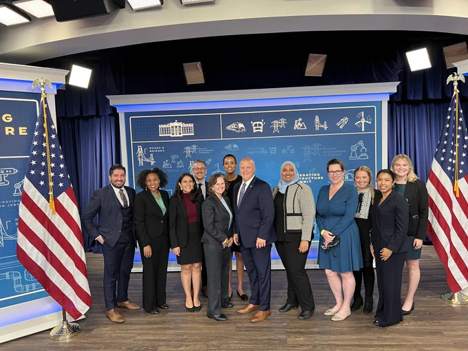 group of individuals in business attire between two american flags