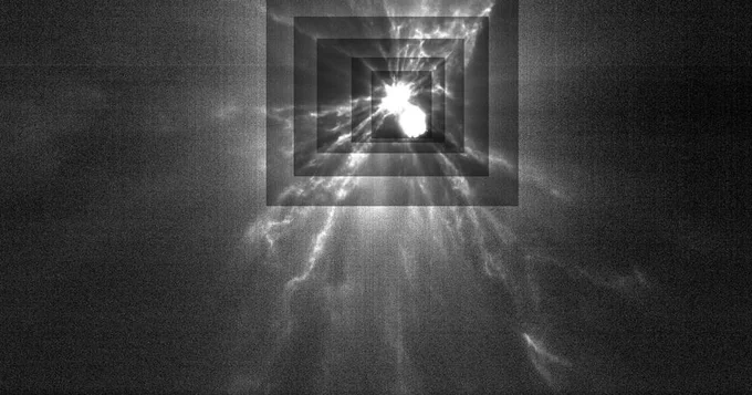 This black and white image was taken by LICIACube, a small cubesat that rode along with NASA's DART mission which impacted the asteroid Dimorphos. Dimorphos is the bright object in the upper center of the image, with filaments of debris streaming out in all directions. The concentric rectangles around Dimorphos indicate successive changes in contrast to bring out details in the ejecta filaments. Credit: ASI/NASA/APL