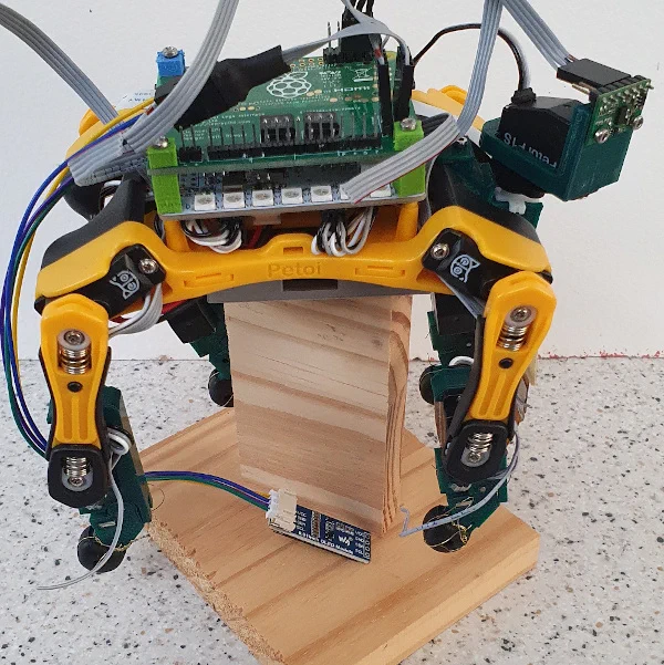 Petoi Dog Robot on a wooden stand with additional electronics added.