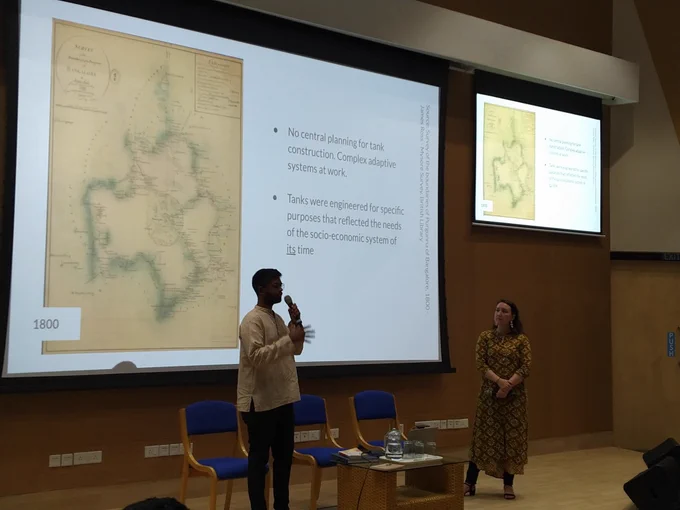 Speaker in front of a British-era map of Bengaluru 