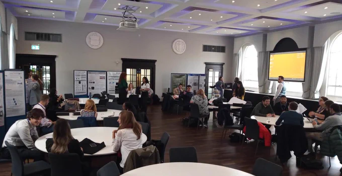 picture of the conference room showing people around and poster boards.