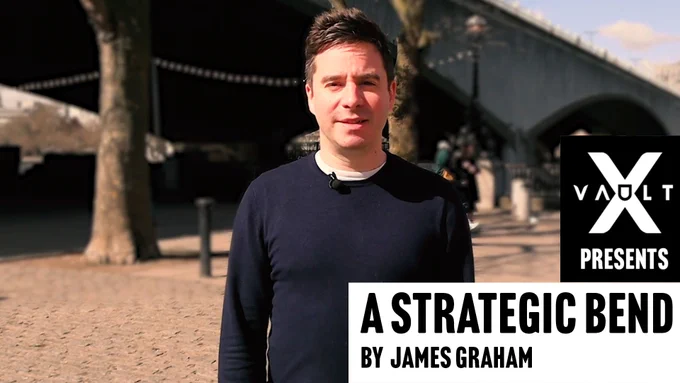Playwright and screenwriter James Graham, a white male in his late thirties with short brown hair and wearing a navy jumper, is seen from the waist up standing in front of Waterloo Bridge. The bridge can be seen arching through the sky behind him. Text over the top of the image reads A Strategic Bend by James Graham. Above the text is the VAULT X logo. 