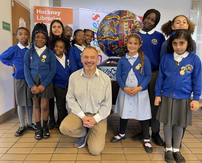 Cllr Chris Kennedy with students from Mandeville Primary School. Local Schools who took part in The World Reimagined learning programme  have created a series of smaller globe sculptures that are on display at Homerton Library and Rio Cinema.