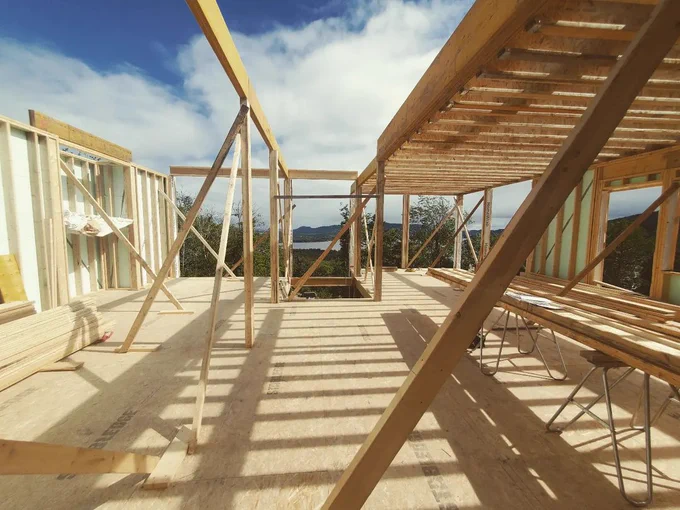An image of the wall framing and subflooring completed on a home with a mountain view. 