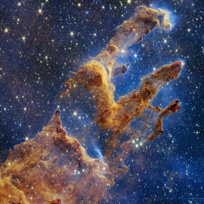 This vertical image has layers of semi-opaque rusty red colored gas and dust that starts at the bottom left and goes toward the top right. There are three prominent pillars rising toward the top right. The left pillar is the largest and widest. The peaks of the second and third pillars are set off in darker shades of brown and have red outlines.