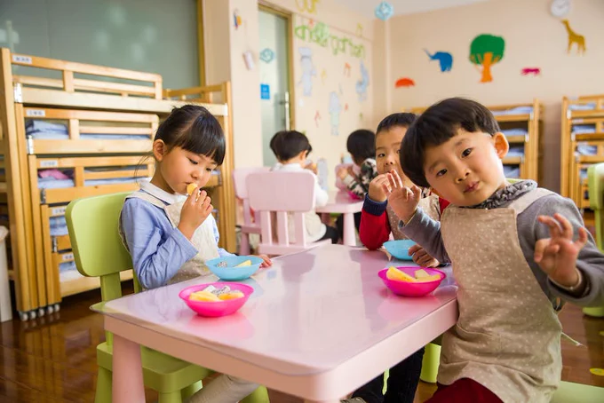 Children in a primary school classroom sitting around a small table.