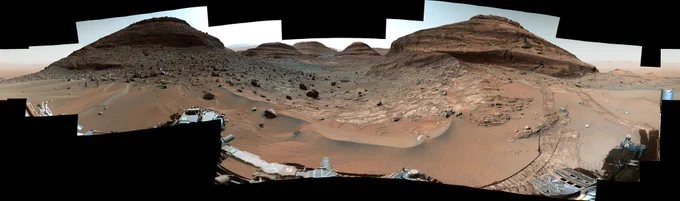 View through Paraitepuy pass, with lots of rocky mounds, sand, and rover tracks.