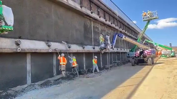 A picture of workers repairing a damaged retaining wall on Northbound I-5 where a brushfire known as the Route Fire burned the wall.