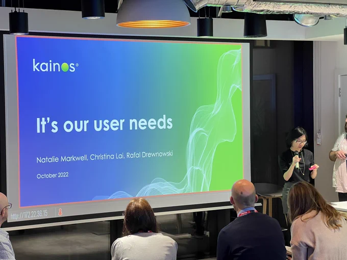 Presenters standing in front of their opening slide. Slide reads 'It's our user needs'