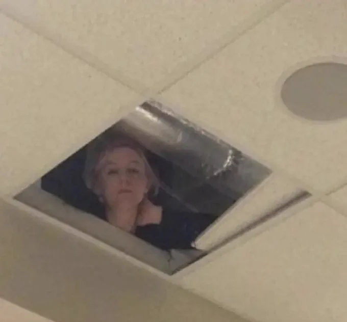 A woman in the ceiling peering down.