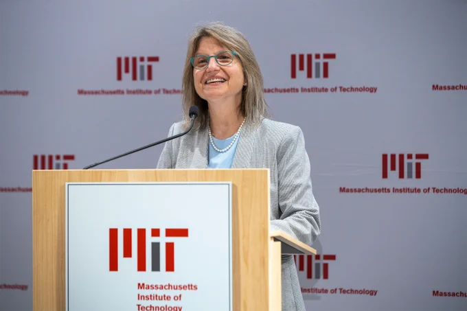 Sally Kornbluth is speaking at a podium. She is standing in front of an MIT step and repeat banner.