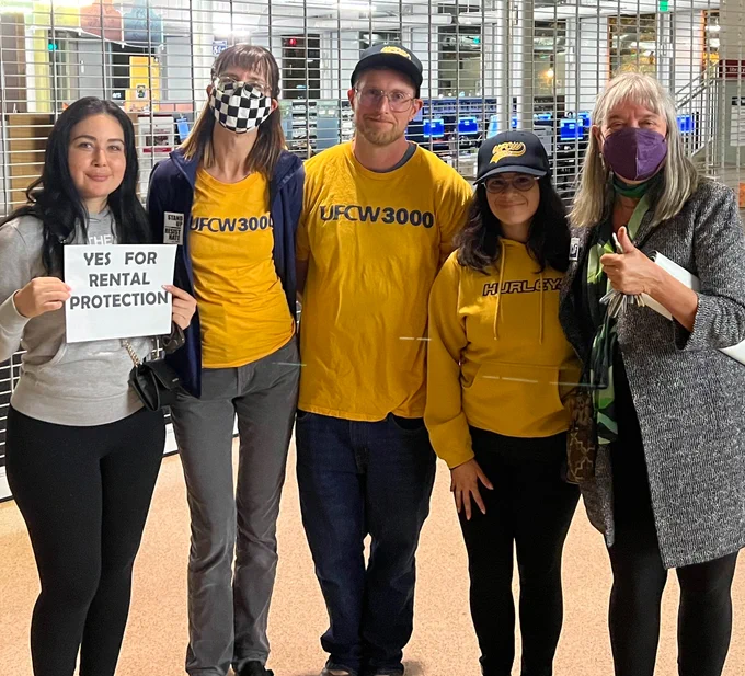 UFCW 3000 members pose for a group photo with community allies. UFCW 3000 members are wearing yellow UFCW shirts and baseball caps.