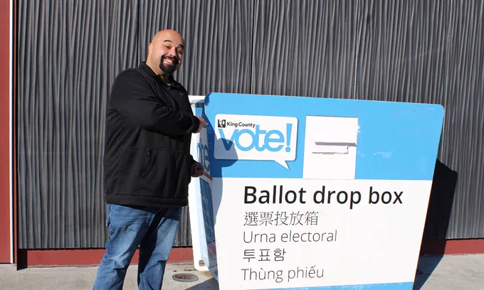 School board director Aaron Garcia at WC Library drop box