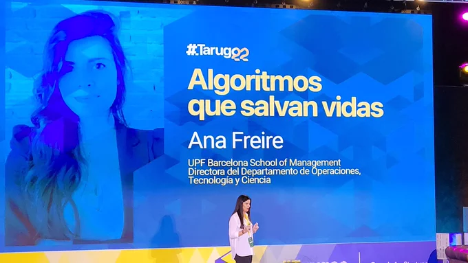 Portada de la charla en la pantalla y Ana en el escenario
