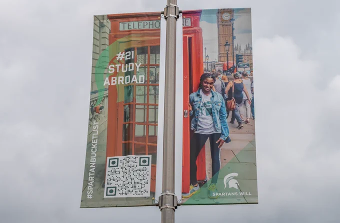Lamp poster banner with a Spartan in London standing next to a red phone booth and the banner says "Study abroad"
