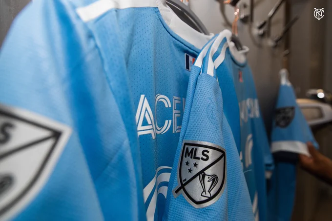 Two NYCFC primary jerseys hanging by the locker room 