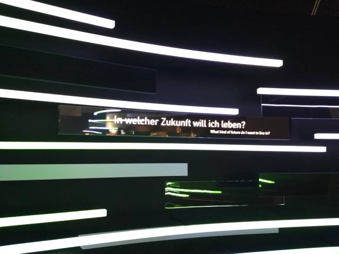 Gezeigt wird ein Foto aus dem Futurium in Berlin. Es sind Lichtleisten zu sehen, dazwischen steht der Satz: "In welcher Zukunft will ich leben?"