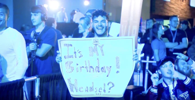 Person with a sign that says "It's MY Birthday! Headset?"