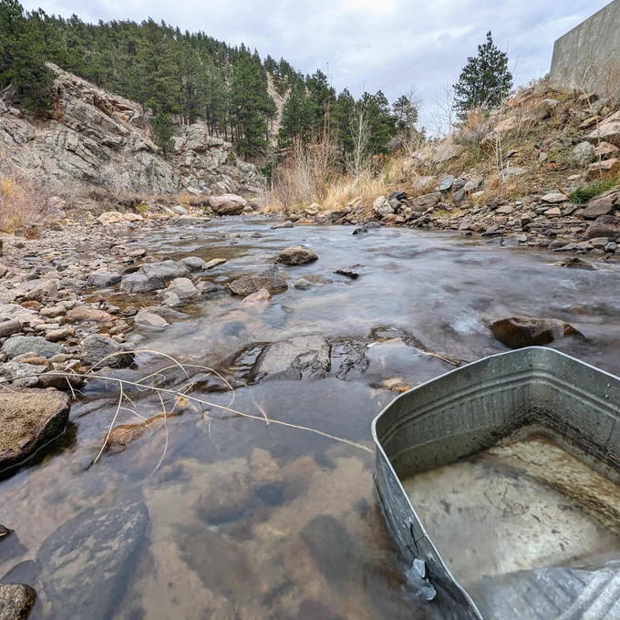 Metal tub in running river