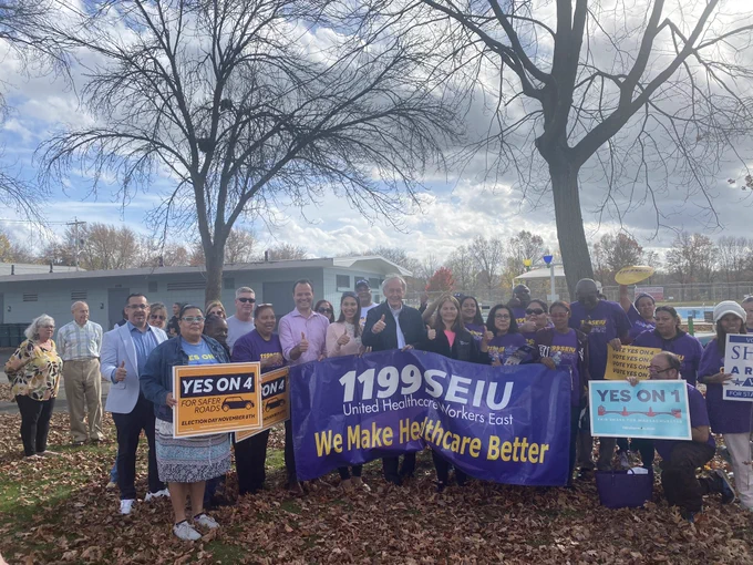 Senator Markey stands with a dozen SEIU 1199 workers and holds a sign with supporters of the Yes on Four and Yes on One campaigns.