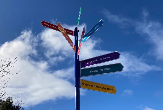 Photo of a colourful direction sign showing the way to Hogwarts and other fun locations chosen by the school children.