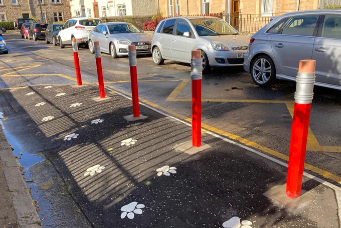Photo of bollards outside school entrance which look like pencils with an eraser.
