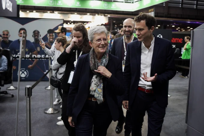 La ministre Geneviève Darrieussecq marche dans les allées du salon Paris Game Week accompagnée de monsieur Vignolles, un des organisateurs du salon.