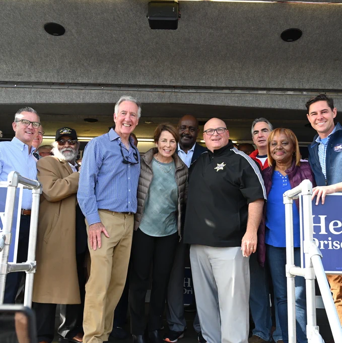 Photo of Maura Healey and Sheriff Cocchi and others at a rally, standing in front of a large crowd 