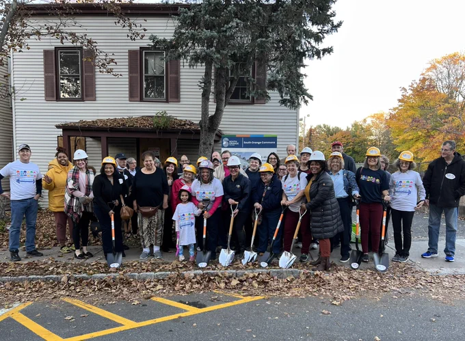 Members of South Orange community standing in front of house and holding shovels to break ground at future location for affordable housing for families and adults with intellectual and developmental disabilities.