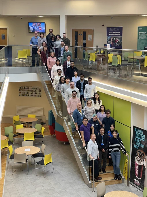 Participants, judges and organisers of the Coventry cultural challenge standing on a staircase looking at the camera.