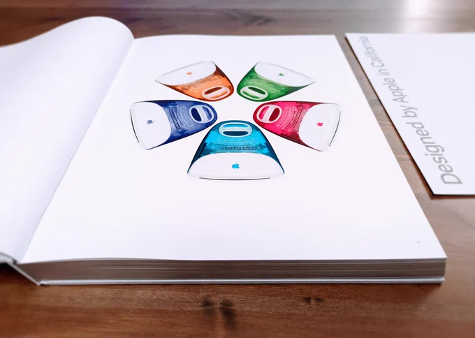 "Designed by Apple in California" photo book, opened on table.