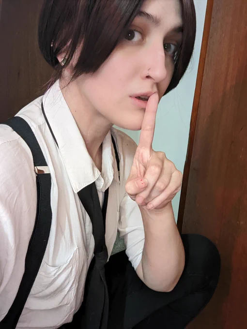 Teshy cosplaying Claire Redfield's noir outfit - white button up, black pants, black suspenders, and a loose black tie.