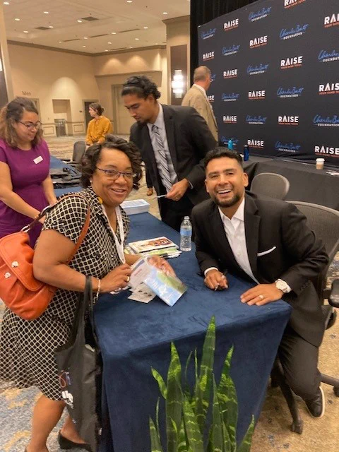 PES principal Genia Antoine with keynote speaker, author and professor Dr. Victor Rios during a book signing at the leadership symposium.