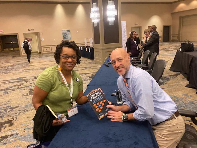 PES principal Genia Antoine with keynote speaker, author and superintendent of Fall Creek School District (Wisconsin) Dr. Joe Sanfelippo during a book signing event at the leadership symposium.