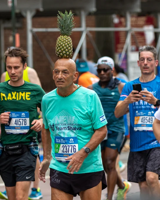 Moshe Lederfien running the New York City Marathon with a pineapple on his head. Photo by Sam Rubin.