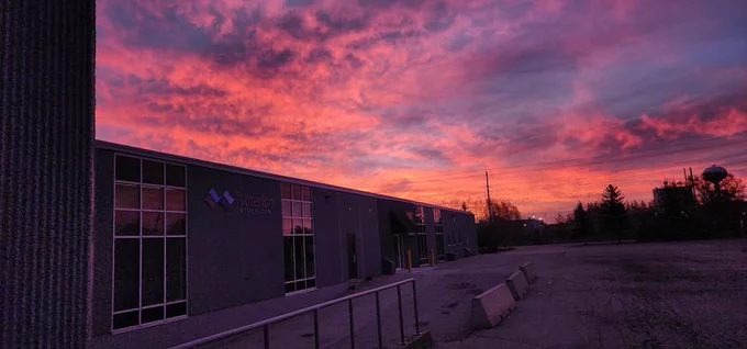 Beautiful red clouds rolling over small to medium sized advanced Wastewater treatment company in Guelph Ontario.