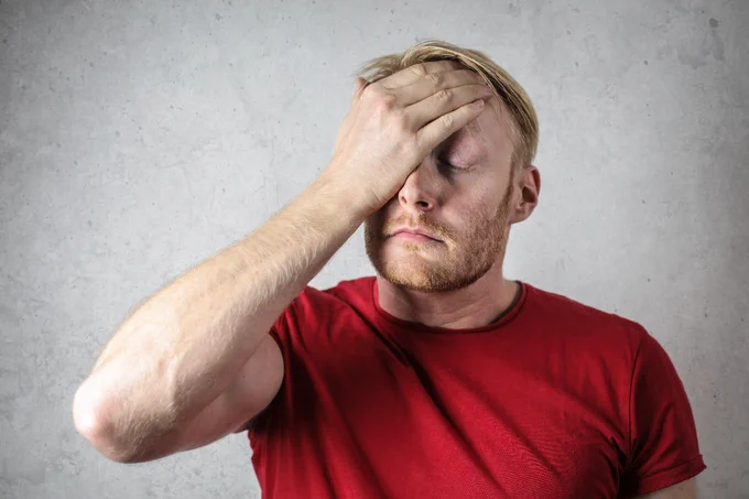 Un Hombre Con Camisa Roja Que Cubre Su Rostro
