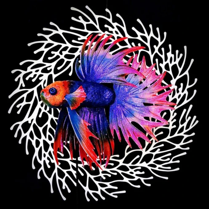 vivid bright blue and orange handmade paper sculpture fish with feathery fins in front of paper coral