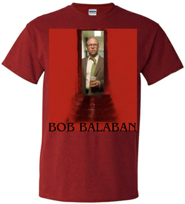 A red t-shirt featuring the doorway from the Barbarian movie poster, only inside is actor Bob Balaban and his name is written below using the Benguiat font.