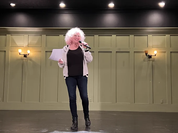 Smiling woman delivers talk on stage.
