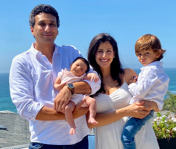 A family of four stands by the beach