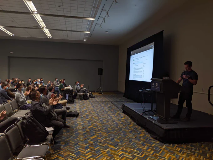 Thomas standing on stage with a github PR